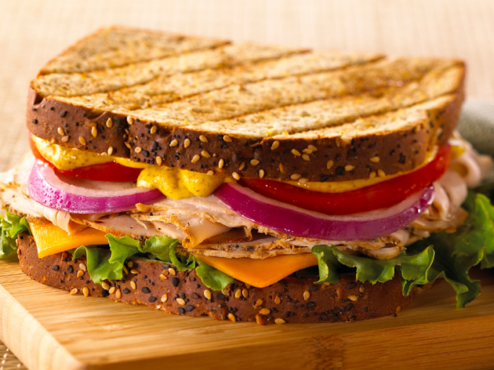 Toasted sandwich with Dijon mustard, red onion, turkey, lettuce and cheddar cheese