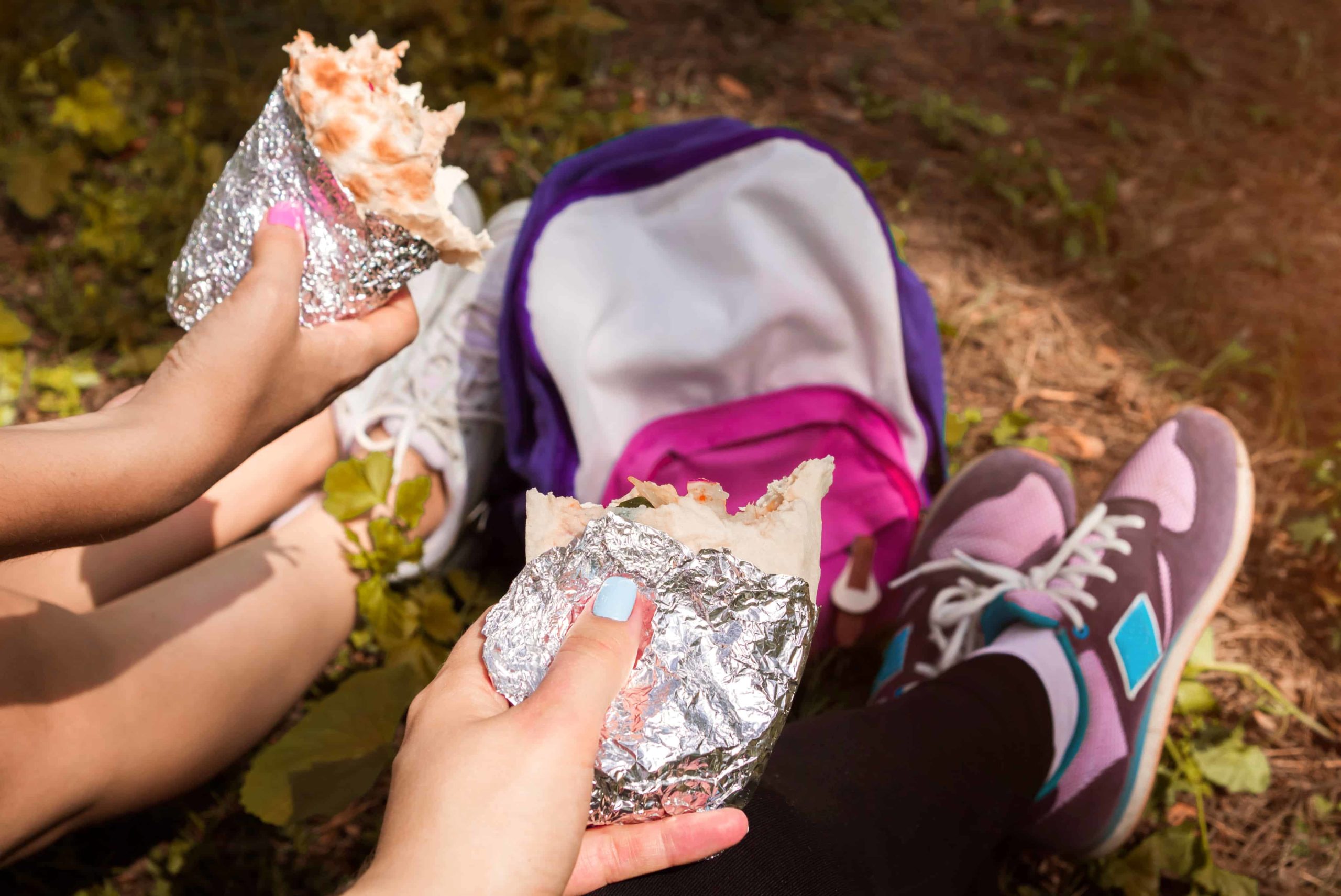 Tourists having rest and eating a sandwich in the forest