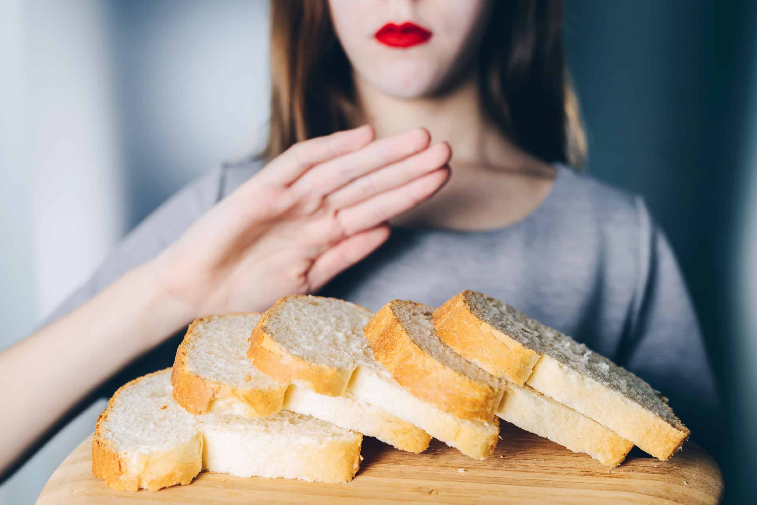 Gluten intolerance and diet concept. Young girl refuses to eat white bread