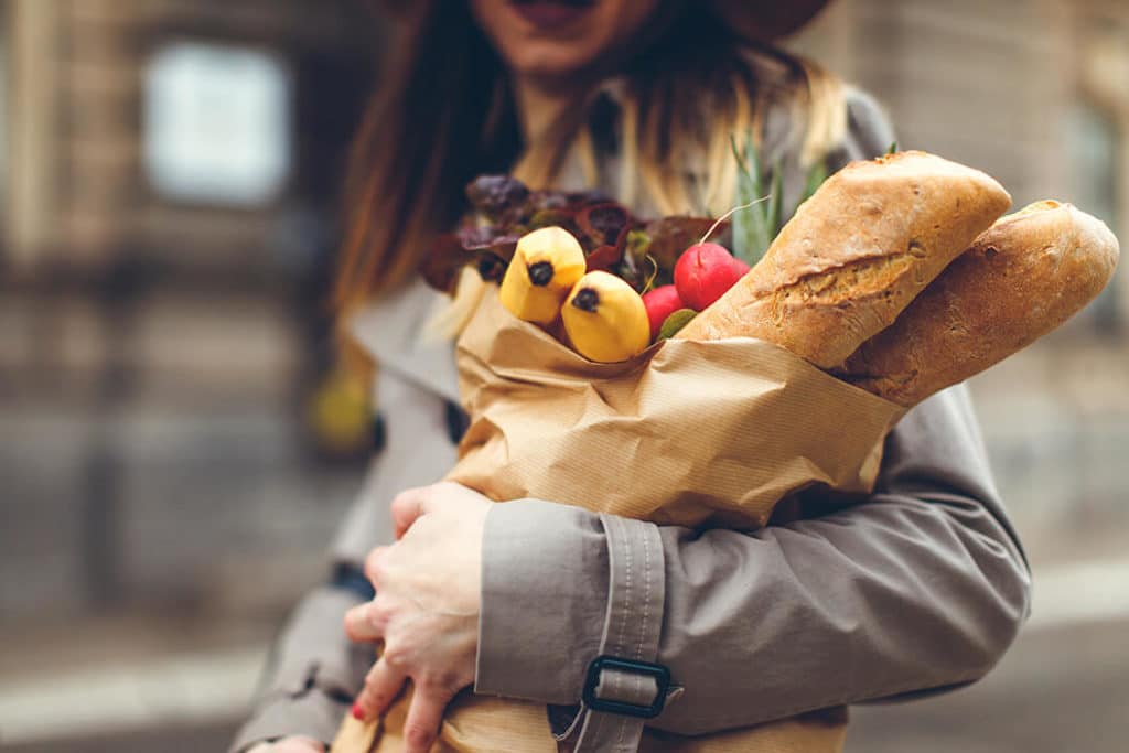 Woman with a grocery bag and baguette