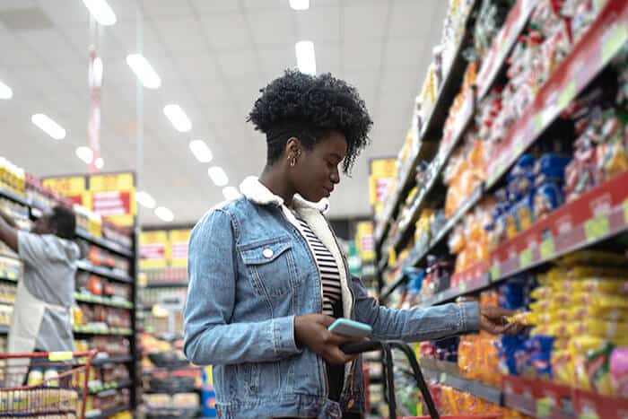 Young woman reading labels while grocery shopping