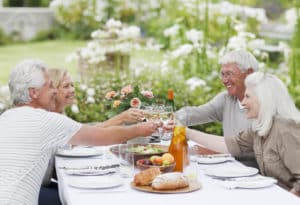 Couples toasting wine glasses at table in garden