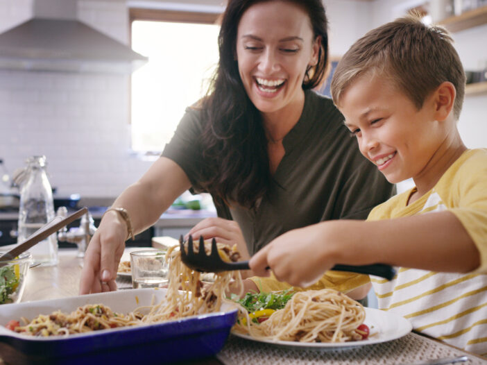 Cropped shot of an affectionate young mother serving her son during a meal on their kitchen table