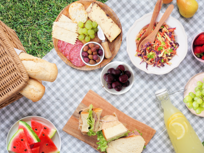 Picnic spread of salads, fruit and sandwiches