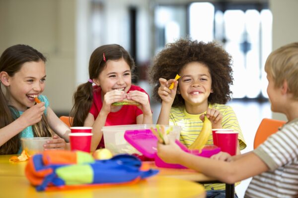 Group of children having packed lunches