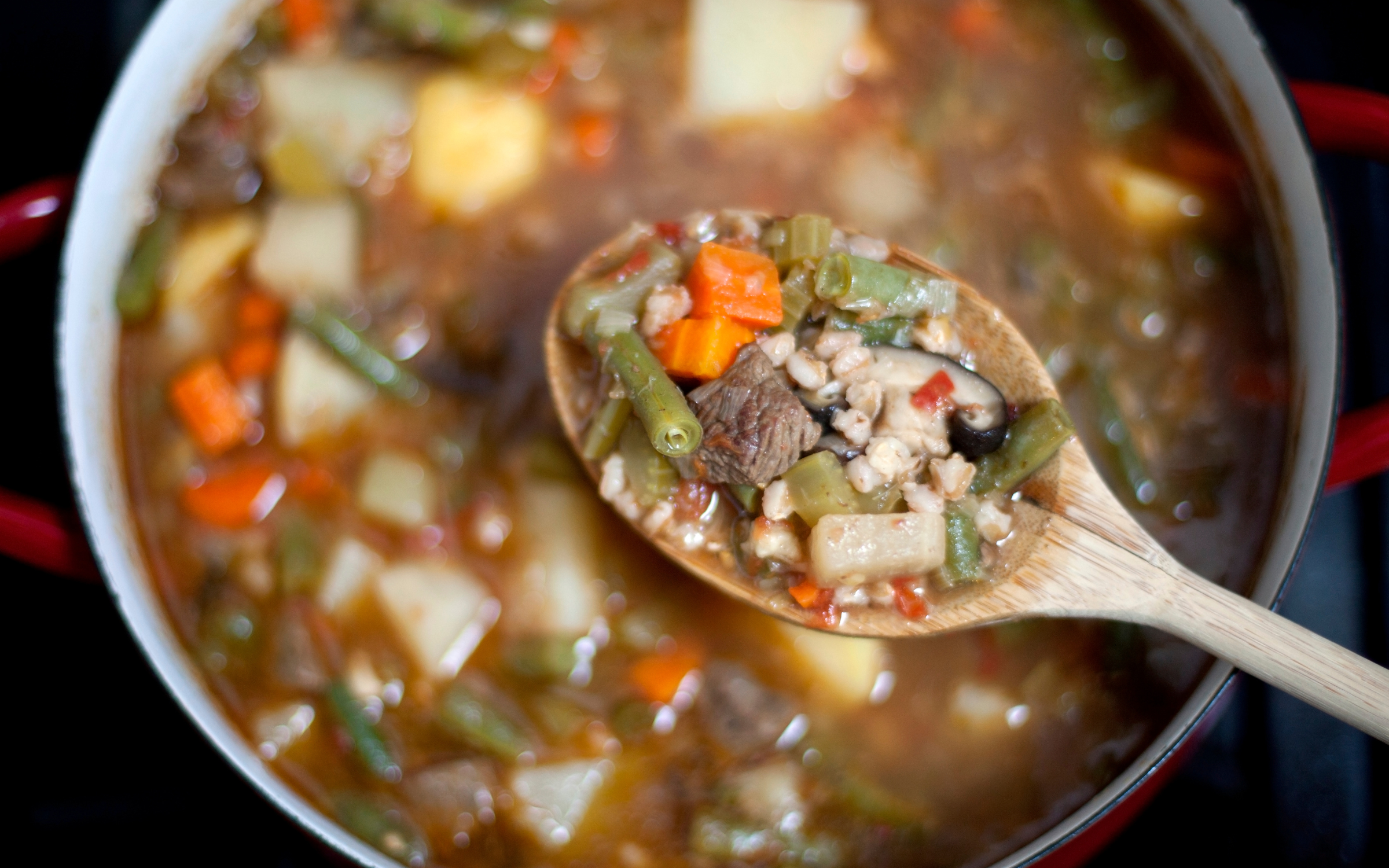 Global Flavors: Bowl of beef and barley soup with a spoon