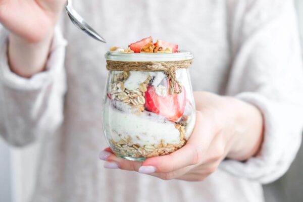 Woman holding granola and yogurt parfait