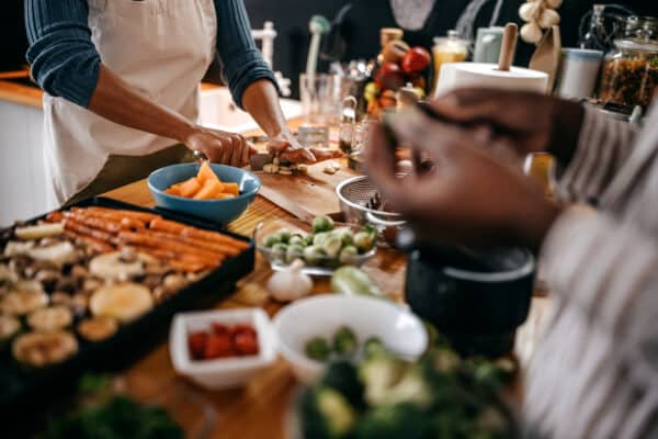 Two female friends preparing food in kitchen for thanksgiving celebration