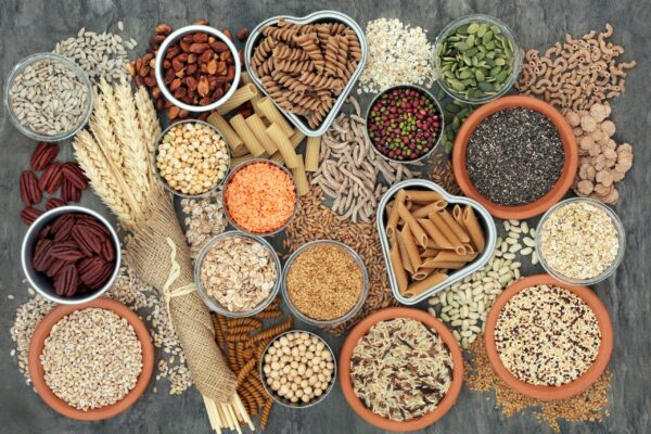 Healthy high fibre dietary food with whole wheat pasta, legumes, nuts, seeds, cereals, grains and wheat sheaths.
