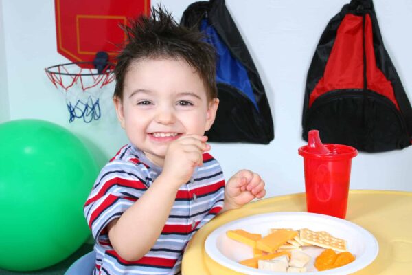 Toddler eating cheese, crackers, orange slices